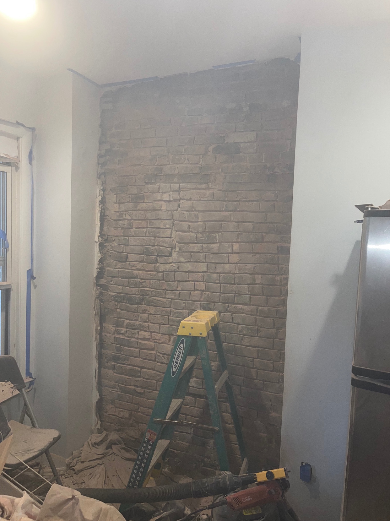 Interior chimney brick wall stripped of plaster during masonry work