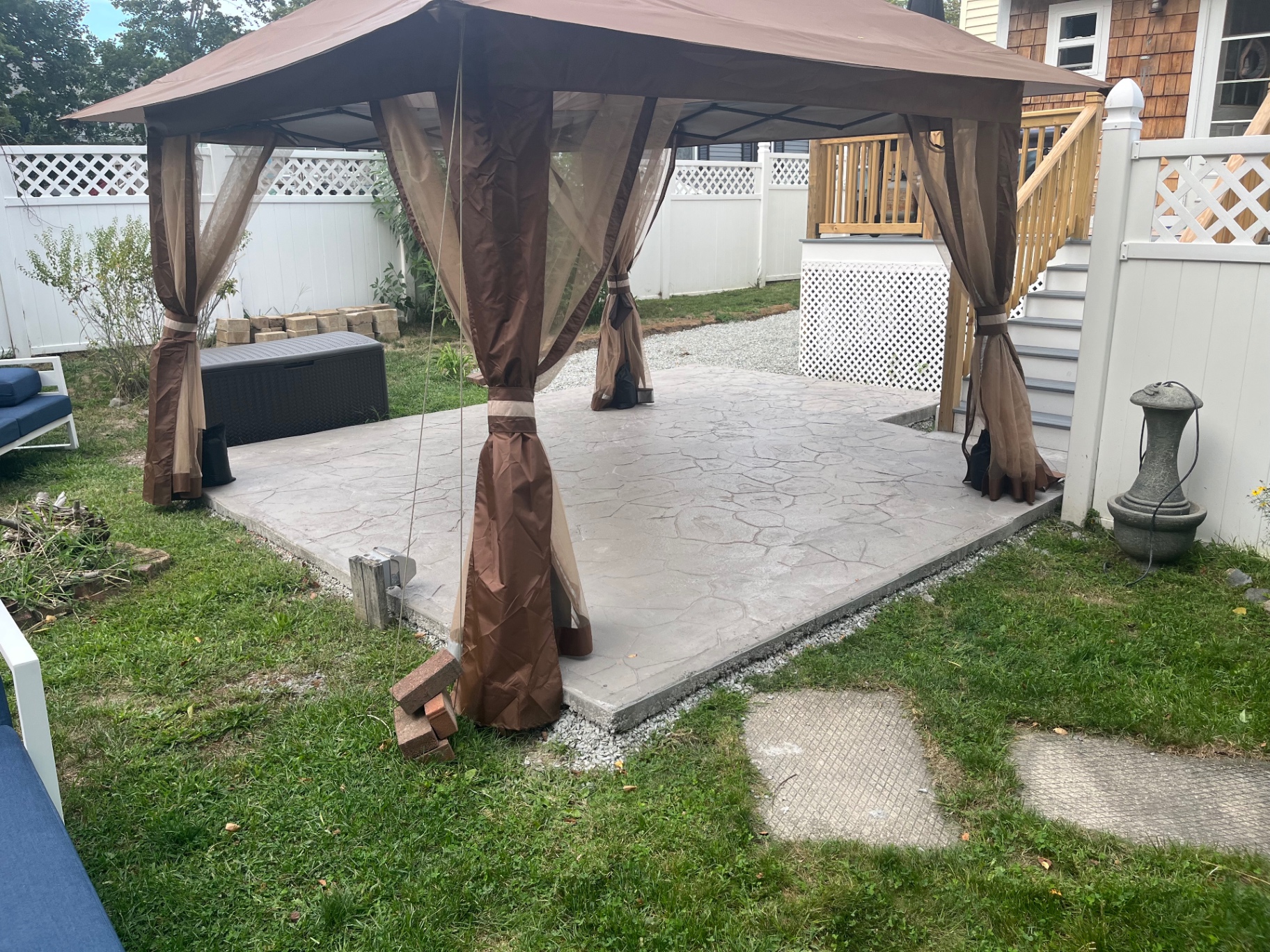 Stamped concrete patio with stone pattern under a backyard gazebo