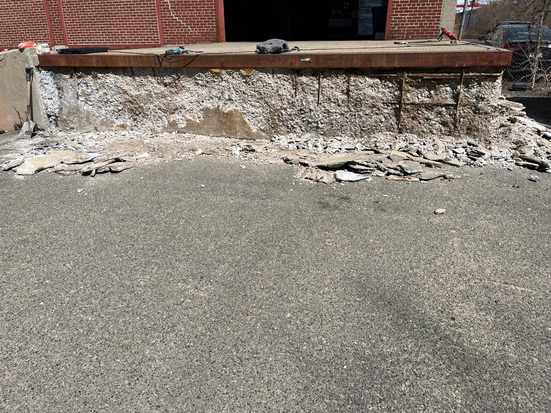 Deteriorated commercial loading dock wall demolished down to rebar