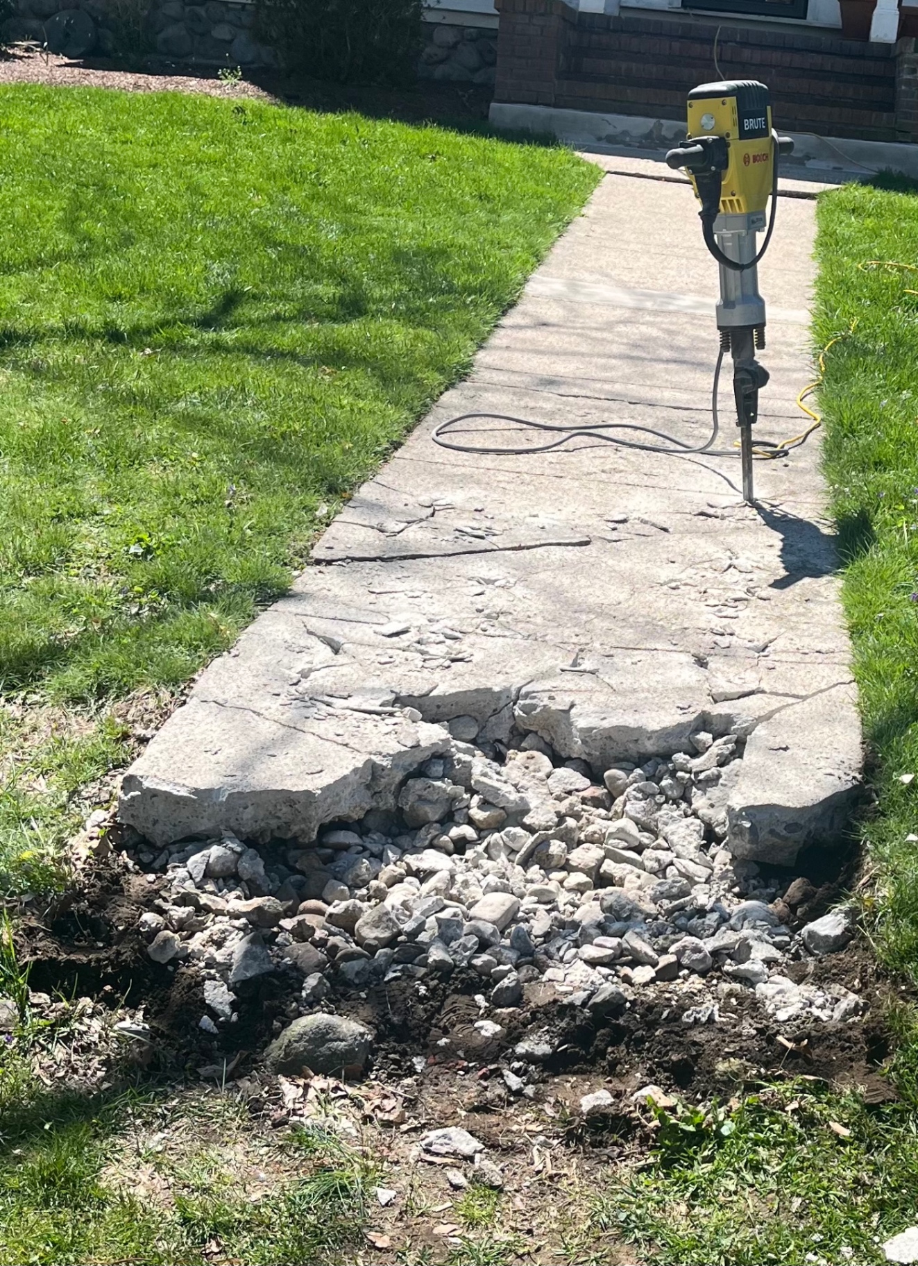 Broken sidewalk being demolished for replacement
