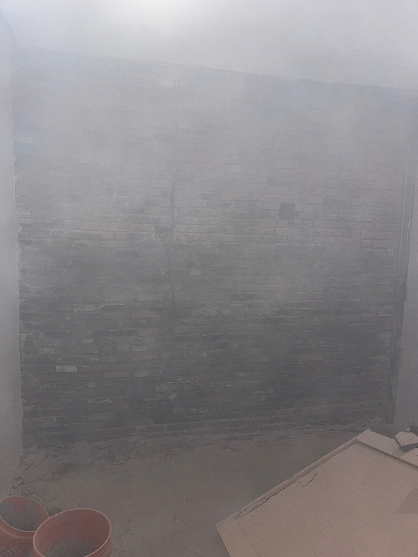 Brick wall being ground and cleaned during interior masonry restoration